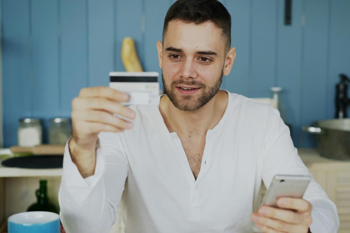 homme qui utilise une carte bleue avec un téléphone